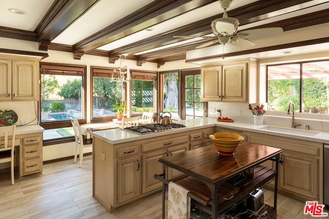 kitchen featuring a kitchen island, light brown cabinetry, sink, stainless steel gas cooktop, and a healthy amount of sunlight