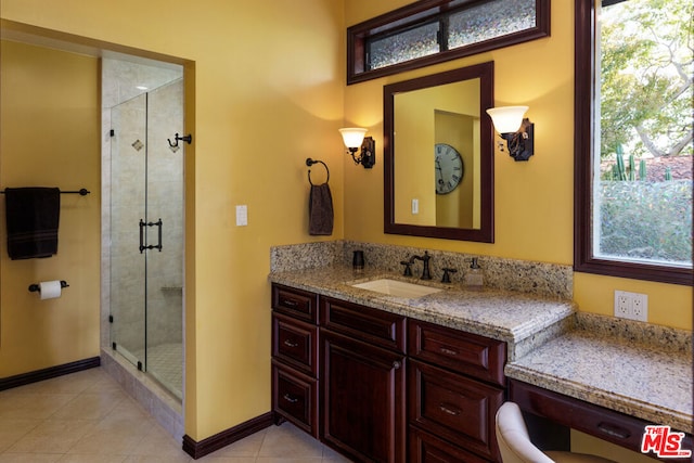 bathroom featuring tile patterned flooring, vanity, and walk in shower