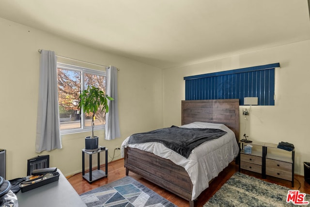 bedroom with dark wood-type flooring