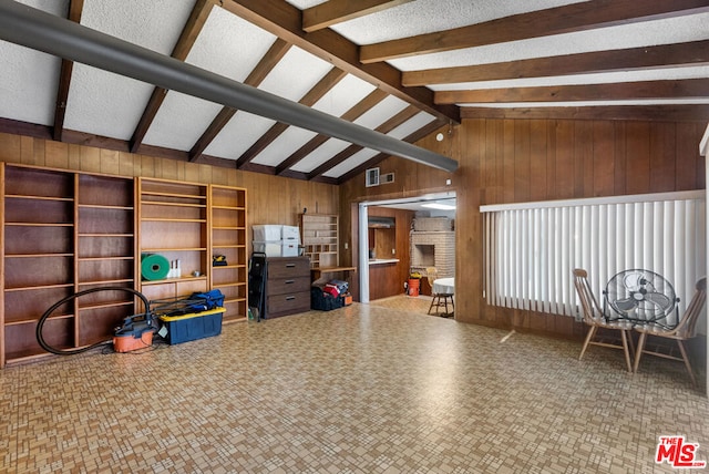 misc room with wood walls and lofted ceiling with beams