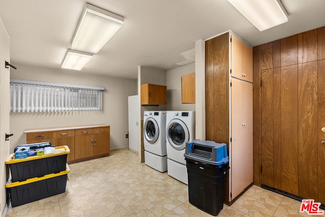 washroom featuring washer and clothes dryer and cabinets