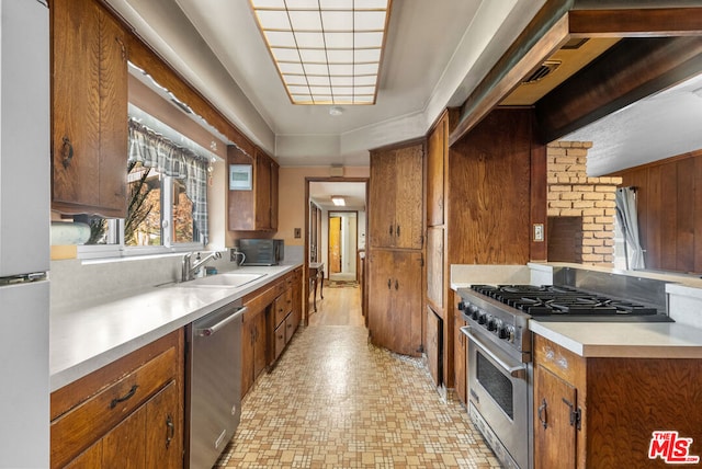 kitchen with stainless steel appliances, wood walls, and sink