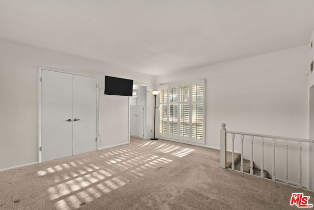 spare room featuring light colored carpet