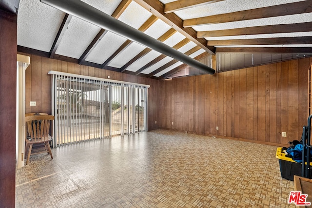 interior space with vaulted ceiling with beams and wooden walls