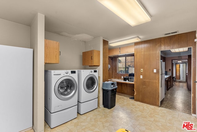 washroom featuring cabinets and washer and clothes dryer