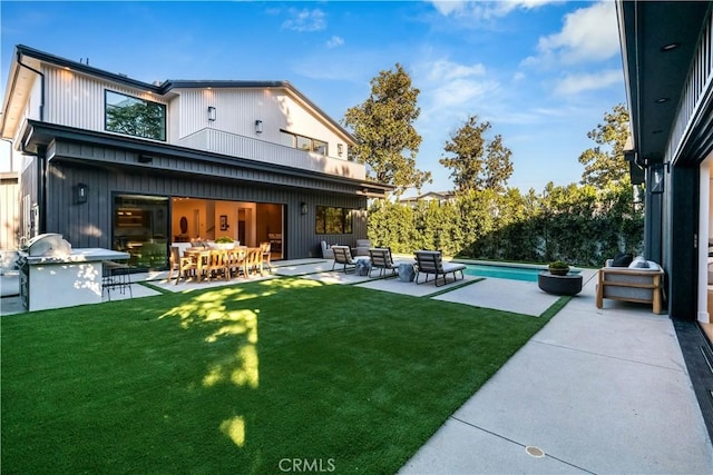 back of property featuring a patio area, a yard, and an outdoor hangout area