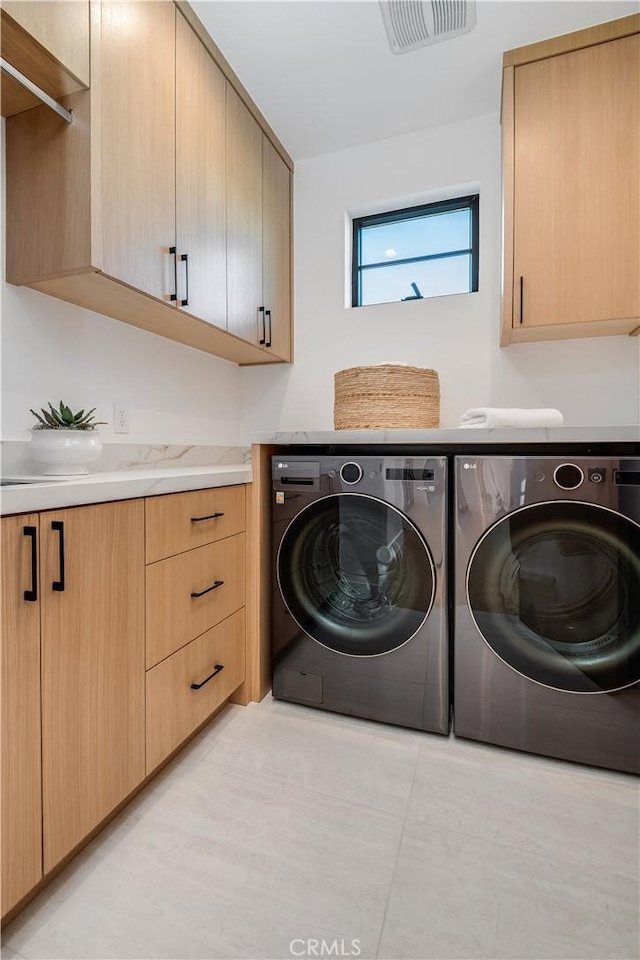 laundry area featuring cabinets and washing machine and clothes dryer