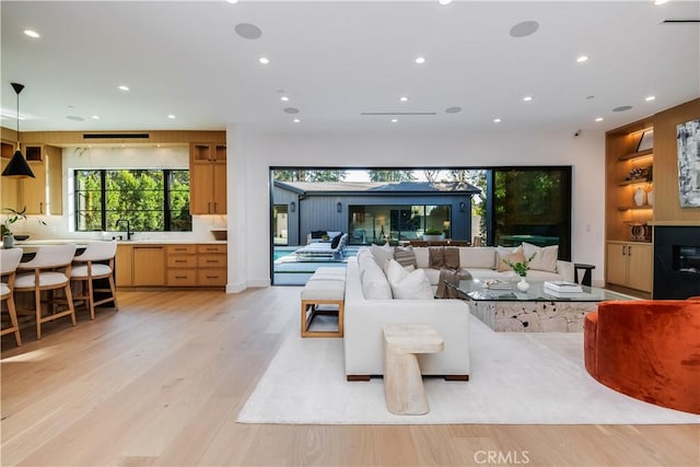 living room with sink and light hardwood / wood-style floors