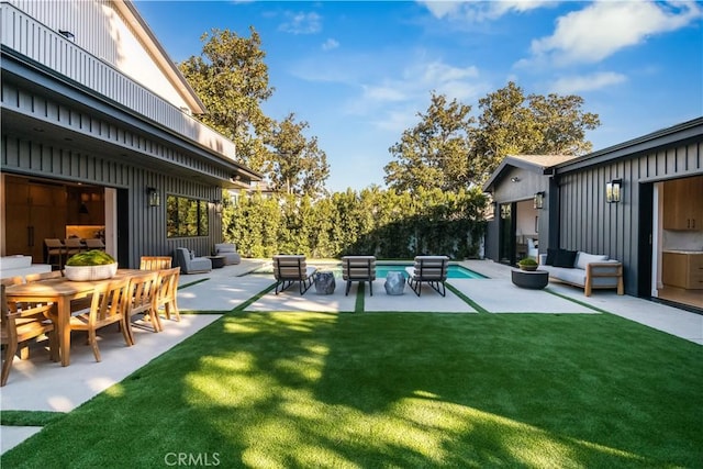 view of yard featuring outdoor lounge area, a fenced in pool, and a patio