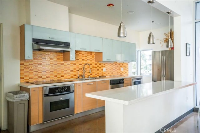 kitchen with sink, backsplash, hanging light fixtures, kitchen peninsula, and stainless steel appliances