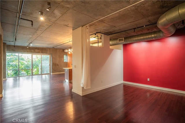 basement featuring a notable chandelier and dark hardwood / wood-style flooring