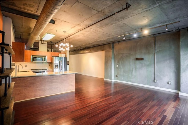 kitchen with stainless steel appliances, sink, dark hardwood / wood-style flooring, and kitchen peninsula