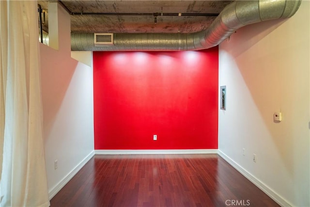 unfurnished room featuring dark hardwood / wood-style floors and rail lighting