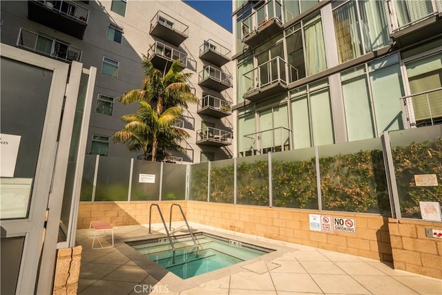 view of swimming pool featuring a patio area and a community hot tub