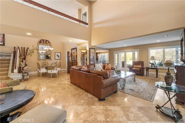 living room with a towering ceiling and an inviting chandelier