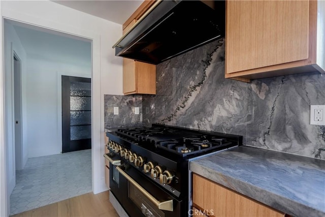 kitchen with range with two ovens, range hood, and backsplash