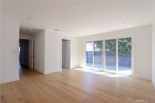 empty room featuring light wood-style flooring and baseboards