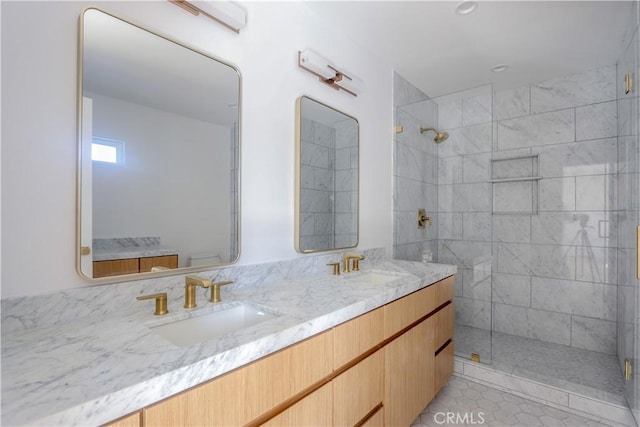 full bath featuring double vanity, a sink, and a shower stall