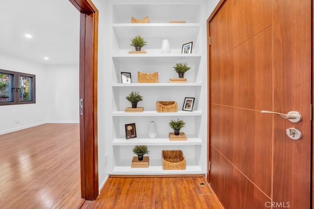 hallway featuring light hardwood / wood-style floors and built in features