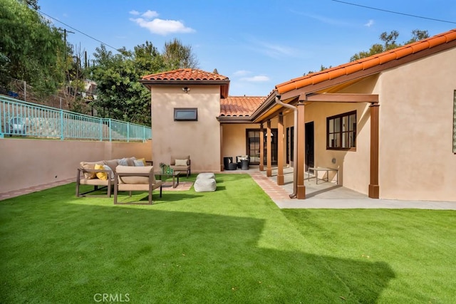 rear view of house with an outdoor living space, a patio area, and a lawn