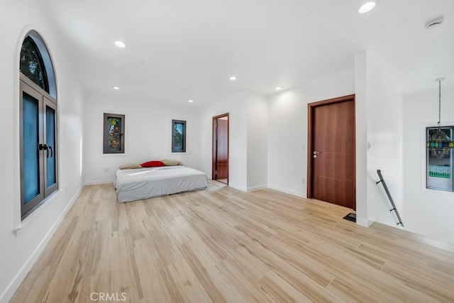 unfurnished bedroom with wine cooler and light hardwood / wood-style flooring