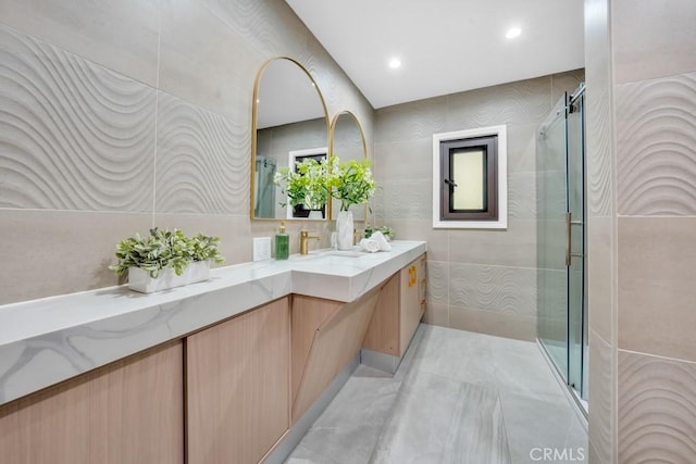 bathroom featuring walk in shower, vanity, and tile walls