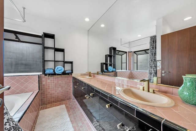 bathroom featuring tiled bath, tile patterned floors, and vanity