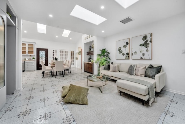 living room with lofted ceiling with skylight and french doors