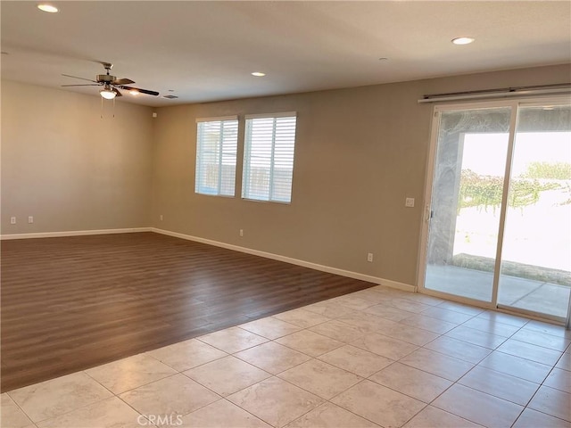 tiled spare room featuring ceiling fan