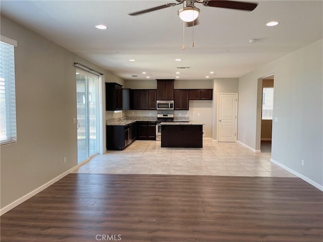 kitchen with light wood-type flooring, a wealth of natural light, stainless steel appliances, and a center island