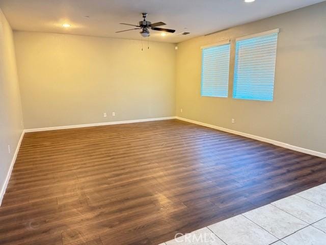 empty room with ceiling fan and dark hardwood / wood-style floors