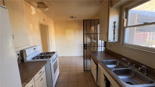 kitchen with plenty of natural light, sink, white cabinets, and white appliances