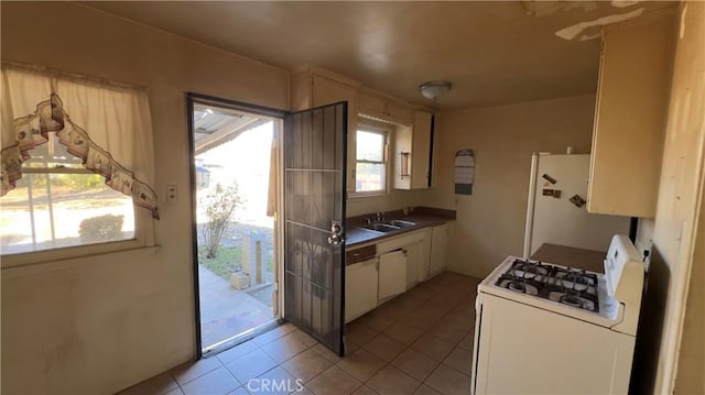 kitchen featuring light tile patterned floors, sink, and white appliances