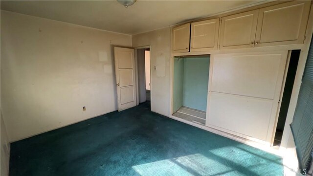 unfurnished bedroom featuring a closet and dark carpet