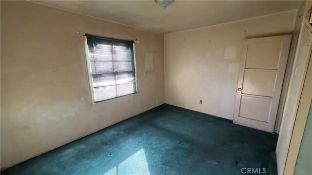 spare room with dark colored carpet