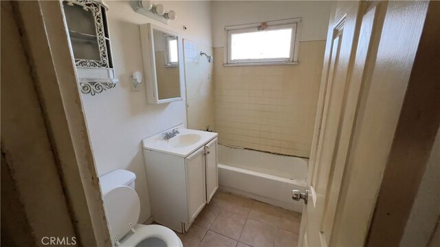 full bathroom featuring toilet, tile patterned flooring, tiled shower / bath combo, and vanity