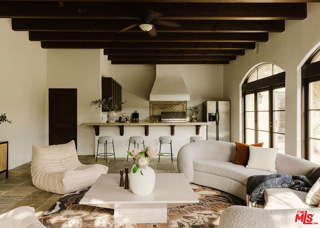 living room with ceiling fan and beamed ceiling