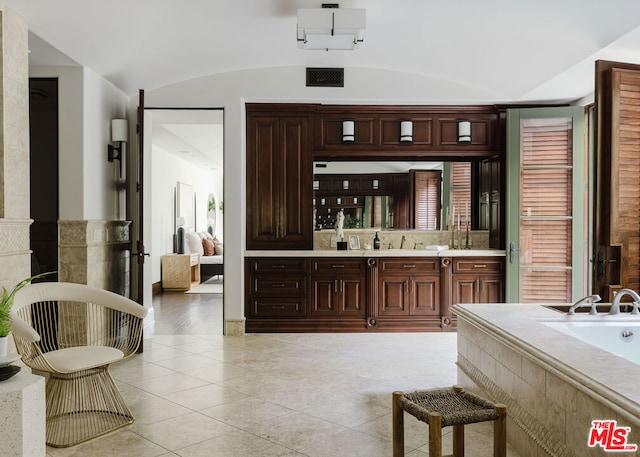 bathroom featuring a washtub, vanity, and vaulted ceiling