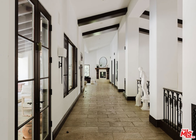 hall with beam ceiling, french doors, and high vaulted ceiling