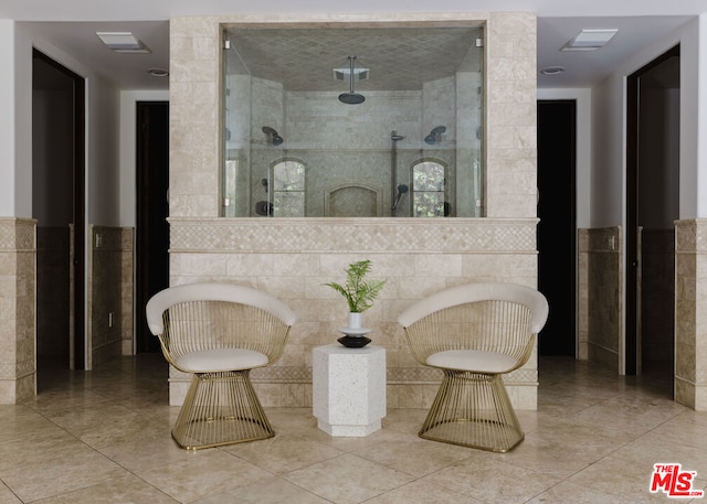 bathroom featuring tile walls and a shower with door