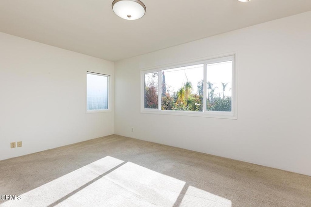 unfurnished room featuring light carpet