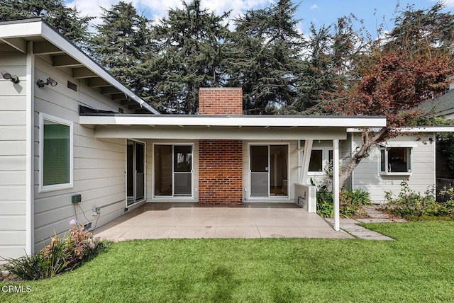 rear view of property featuring a patio area and a lawn