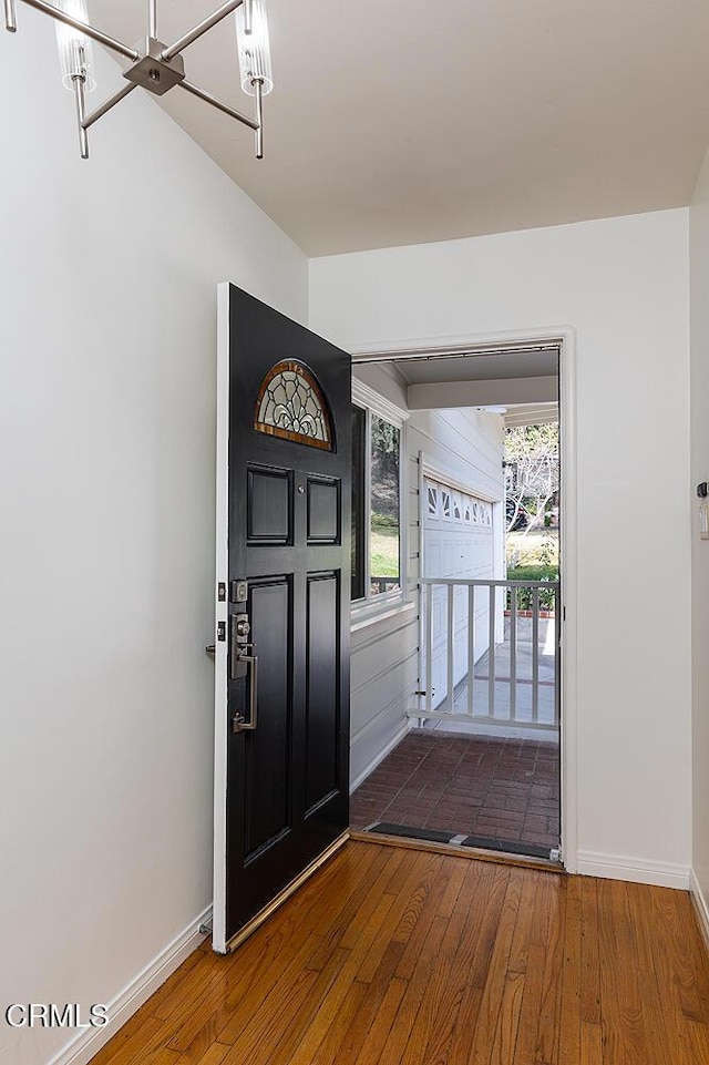 foyer with a notable chandelier and hardwood / wood-style flooring