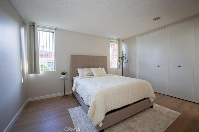 bedroom featuring wood-type flooring and a textured ceiling