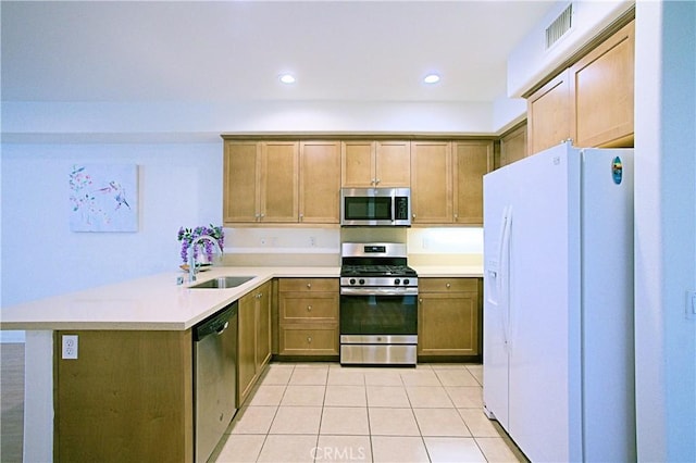 kitchen featuring light tile patterned flooring, stainless steel appliances, kitchen peninsula, and sink