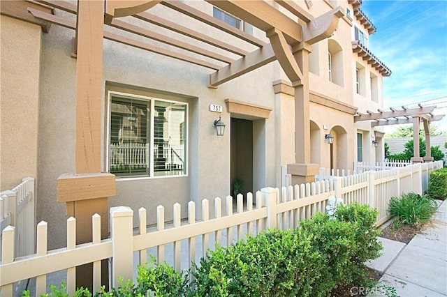 view of exterior entry with a pergola