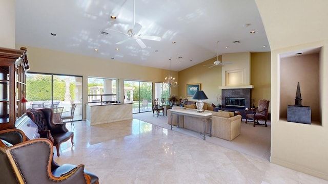 living room with ceiling fan with notable chandelier, a large fireplace, and high vaulted ceiling