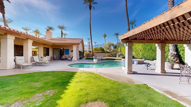 view of pool featuring a lawn and a patio