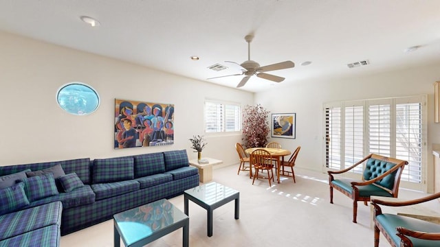 living room with ceiling fan and light colored carpet