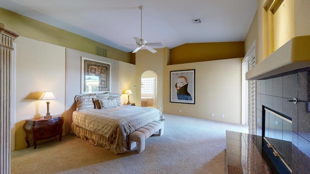 bedroom featuring light carpet, ceiling fan, lofted ceiling, and a fireplace